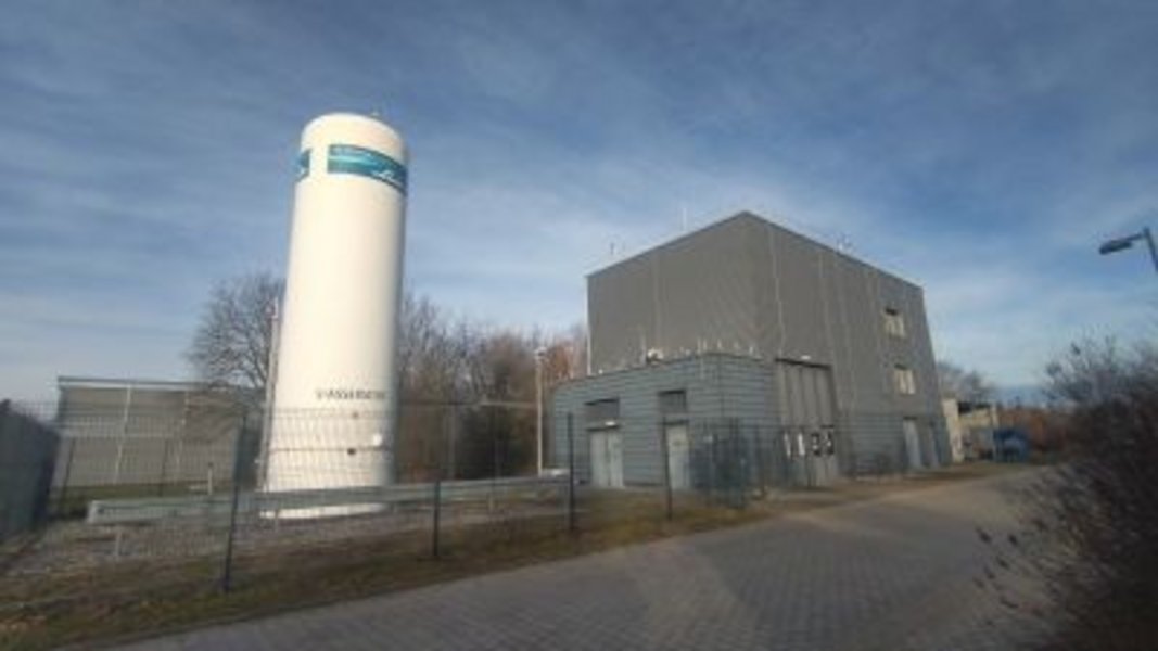 Blick von außen auf die Gebäude des Wasserstoff- und Speicherforschungszentrum der BTU Cottbus-Senftenberg. Der hohe, weiße Wasserstoffspeicher sticht auf dem Bild hervor.